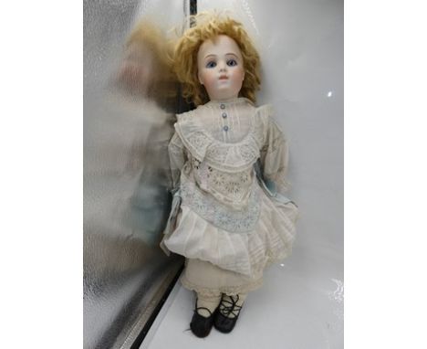 A Bru Jeune shoulder plate bisque doll, with fixed blue paperweight eyes, brown feathered brows, closed mouth with slight gap