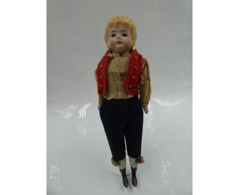 A China dolls house doll dressed as a boy, with yellow moulded hair, painted features, white moulded socks and black heeled b