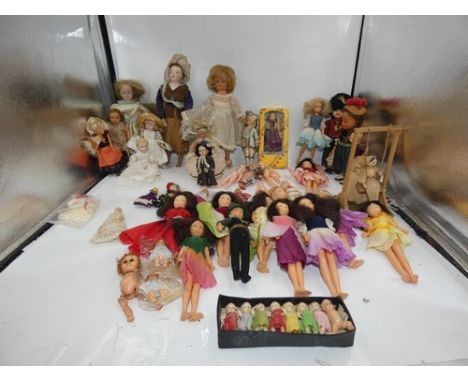 A good selection of 20th Century bisque, celloid and plastic dolls including a Kewpie style doll, eleven fairy dolls, eight R