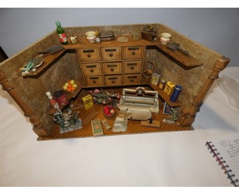 A wooden Dutch grocer's shop with nine drawers to centre with shelves either side, with various basket of fruit, flowers, a p