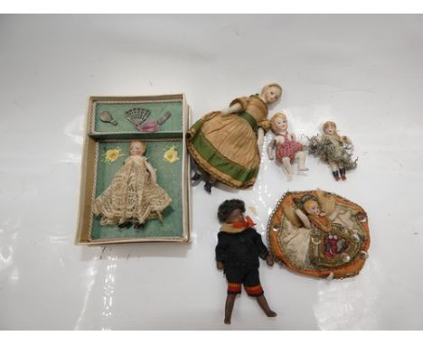 A collection of 6 assorted dolls house dolls and miniature jointed bisque dolls including a mulatto bisque dolls house doll, 