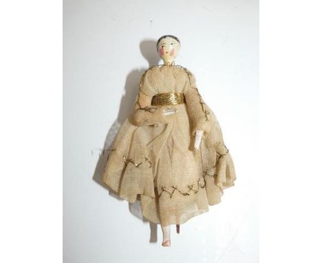 A 19th Century wooden doll with painted black hair, painted eyes and lips, rosy cheeks, comb missing from hair, jointed body,