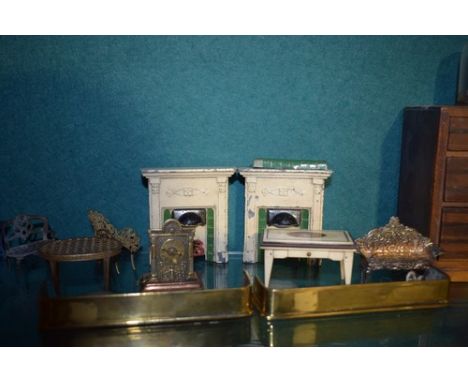 A selection of dolls house furniture including two metal fireplaces, three mantelpiece clocks, a veneer chest of drawers etc.