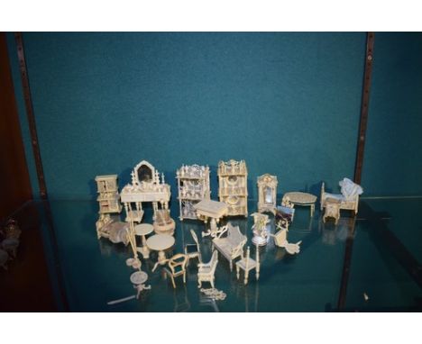 A good collection of dolls house miniature bone furniture including a mirrored dressing table, two beds, a drinks holder with