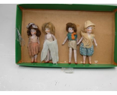 Four all bisque jointed dolls, house dolls, one dressed in pink dress with painted heeled shoes and socks, 3¼" (8cm) high, on