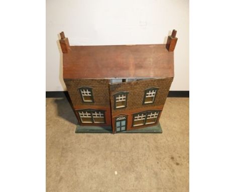 A 20th Century dolls house with panelled door and five windows, with red brick facade and red tile effect roof and two chimne