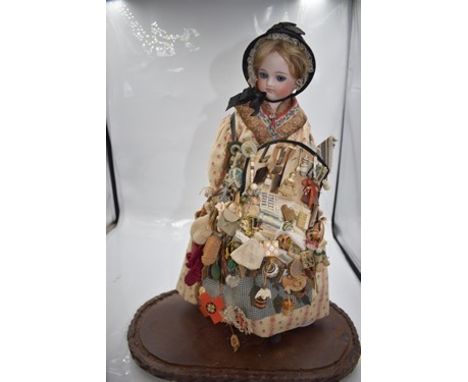 A German Belton type bisque shoulder plate doll, with blue glass eyes, painted eyebrows, eyelashes and lips, with auburn moha