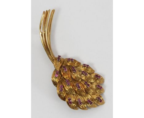An 18ct gold and ruby brooch modelled as a stylised floral bouquet, claw-set with thirty-six small rubies, stamped '750' and 