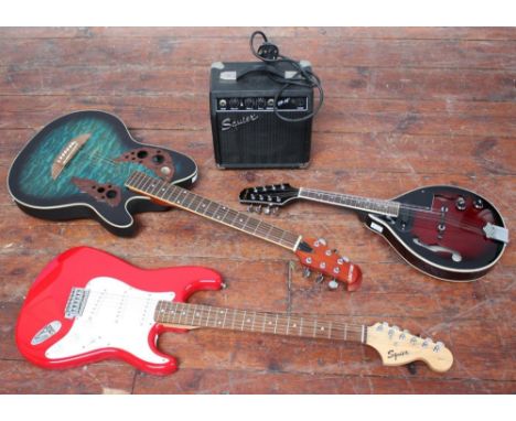 A Stagg electric Mandolin, together with a Squire Strat by Fender electric guitar in red, a round-back Melody acoustic guitar