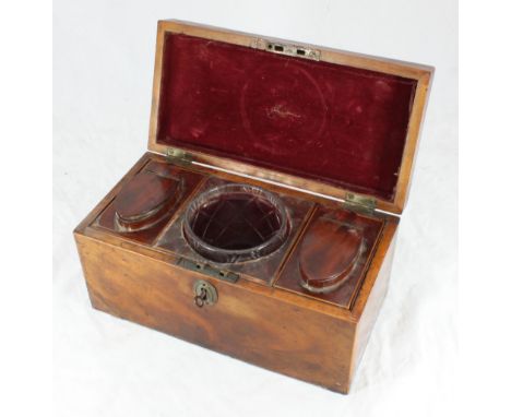 A late 18th century mahogany tea caddy of rectangular form, the hinged cover enclosing a cut glass circular mixing bowl flank