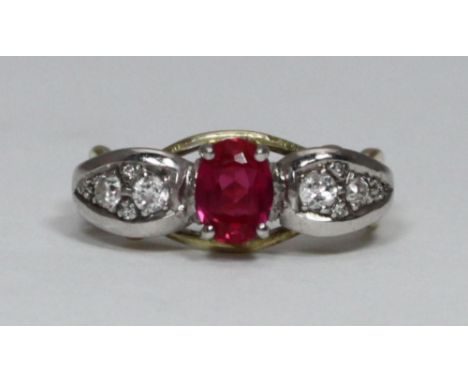 An 18ct yellow gold, ruby and diamond ring, centrally claw-set in rhodium-plated top with an oval faceted ruby, of good comme