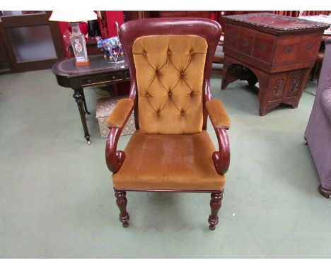 A circa 1860 mahogany library armchair the button back rest over scroll arms on turned and tapering legs