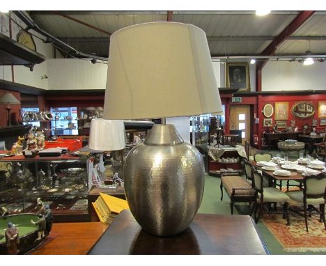 A planished silver coloured table lamp with grey shade  