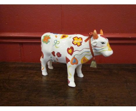 A ceramic money box as a cow cream ground, hearts and flowers design