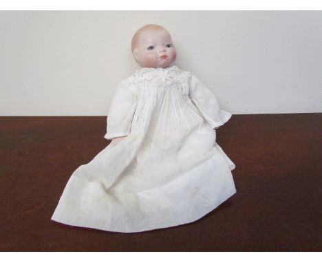 An early to mid 20th Century ceramic headed baby doll 