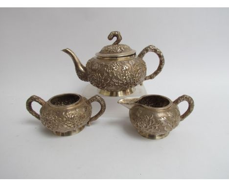 A late 19th early 20th Century Chinese silver three piece tea set, foliate relief, lid detached as hinge pin missing, marks r