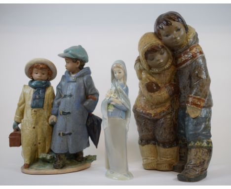 A Lladro pottery group, Eskimo Boy and Girl, 33 cm high, another group, 26.5 cm high and a similar figure, 23 cm high (3)  Co