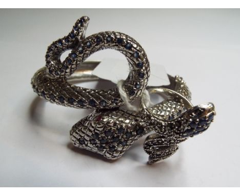 A silver and sapphire bangle, in the form of a snake, and a similar ring (2)