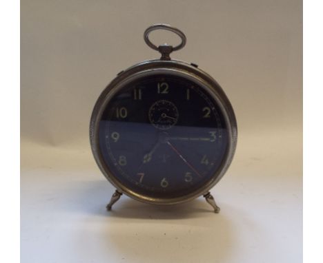 A German alarm clock, the 10.5 cm diameter black dial with Arabic numerals, in a nickel plated case, 18 cm high Condition rep