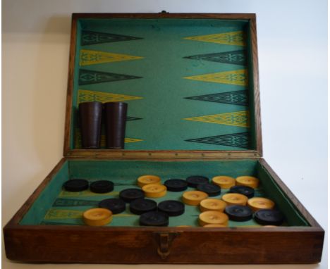 An oak travelling backgammon set, with treen counters, leather shakers and two dice 