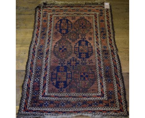 A Baluch rug, decorated geometric motifs on a light red ground, within a multi border, 89 x 135 cm