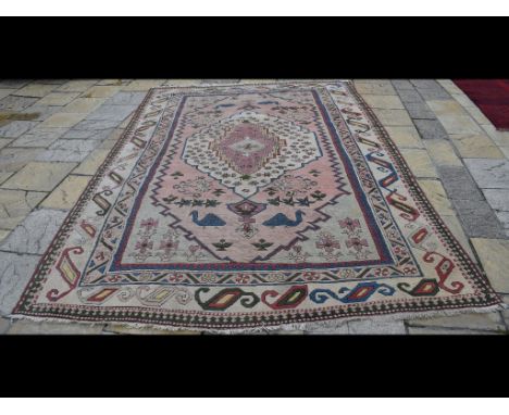 A Turkish Milas carpet, decorated animal and foliate shapes on a cream ground, within a multi border, 367 x 238 cm