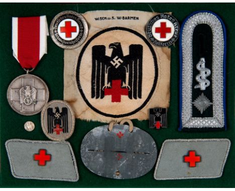 A group of German World War II Red Cross awards, including a medal, arm badge, enamel badges and other items, in a case  See 