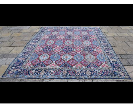 A Persian Kirman carpet, decorated floral panels on an ivory ground, within a multi border, 365 x 258 cm