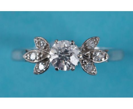 An 18ct white gold and solitaire diamond ring, the fancy leaf shoulders set diamonds, approx. ring size R  See inside back co