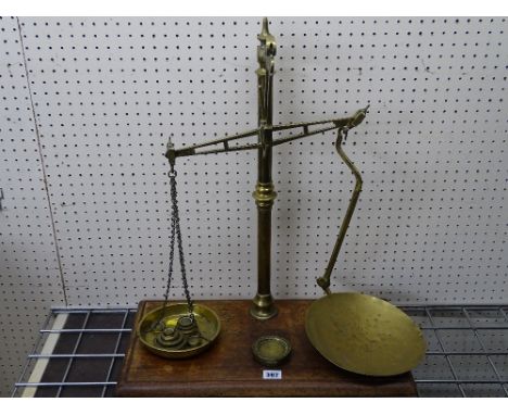 Set of brass provision scales on a mahogany base with several weights