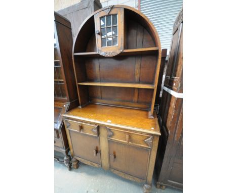 A Mid 20th century oak Dutch style dresser the arched raised back with a single glazed door above an enclosed shelf, rectangu