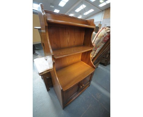 An Ercol elm bookcase with 2 open shelves above 2 cupboard doors.