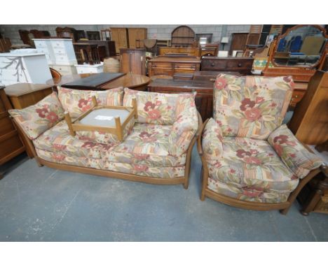 An Ercol cottage type lounge suite with floral pattern loose cushions comprising settee, armchair and footstool. 