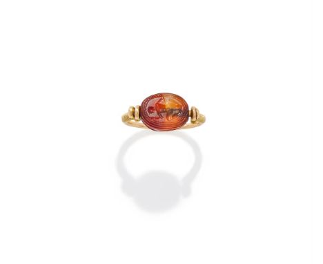 AN ANTIQUE ETRUSCAN RIVIVAL GOLD AND CARNELIAN SEAL RING   The antique carved and polished cornelian scarab beetle bead, the 