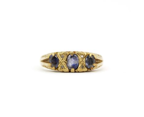 A hallmarked 9ct yellow gold ring set with oval cut tanzanites, (O.5).