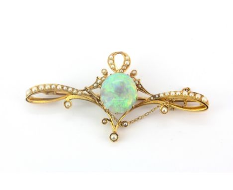 A yellow metal (tested high carat gold) brooch set with a cabochon cut opal and seed pearls, approx. 6.3ct opal L. 7cm.