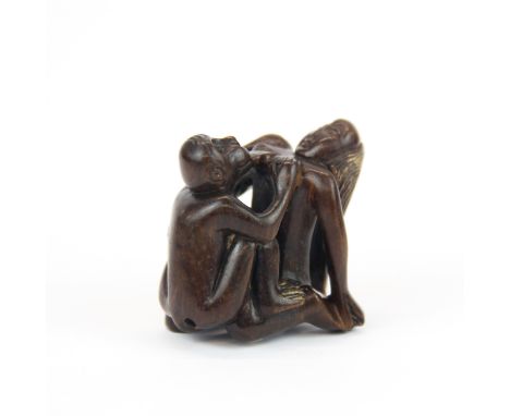 An erotic carved fruitwood Netsuke with inset mother of pearl signature panel, H. 4.5cm.