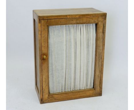 A light oak food cabinet with fabric panel to door and shelves within, 57cm wide x 77cm tall 