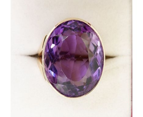 A 9 carat gold handmade large oval cut Brazilian amethyst ring with deep engraved band setting made by Peter Ball (studio jew