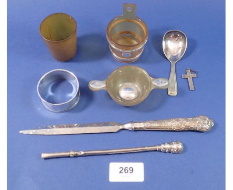 A silver handled paperknife, silver napkin ring, silver and horn handled miniature wine taster, silver crucifix, plated caddy