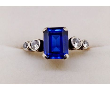 An 18ct gold ring set rectangular cut blue stone flanked by four white stones, size M to N 