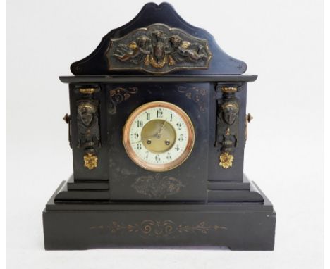 A Victorian black slate large mantel clock with cherub and mask decoration, 51cm tall 