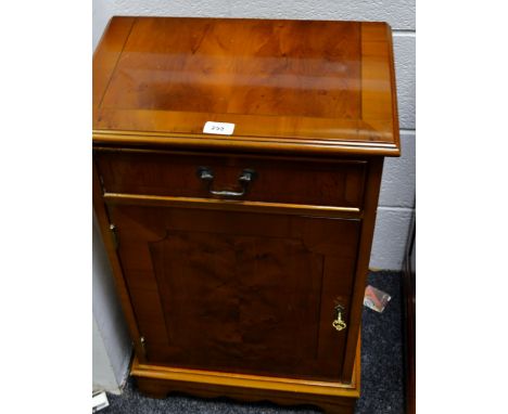 A walnut bedside cabinet, single drawer over single door, shaped apron, bracket feet.