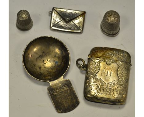 A silver vesta case, Birmingham 1899;  a novelty stamp case in the form of an envelope;  a silver caddy spoon;  silver thimbl