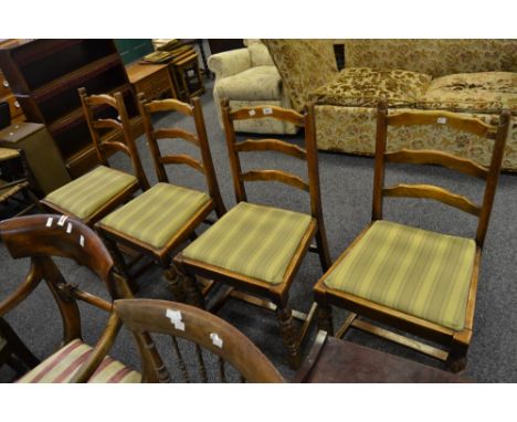 A set of four Edwardian ladder back dining chairs, heavily carved supports of exotic flowers