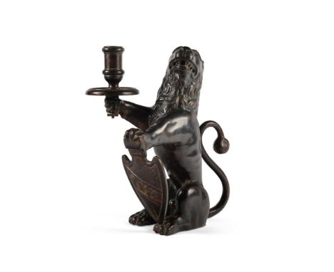 A BRONZE LION CANDLESTICK  PROBABLY NUREMBERG, 17TH CENTURY  Depicted sejant, candleholder in front right paw, shield to left