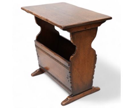 Oak magazine rack or side table, rectangular top on shaped end supports and sledge feet, panelled sides with chip carved deco
