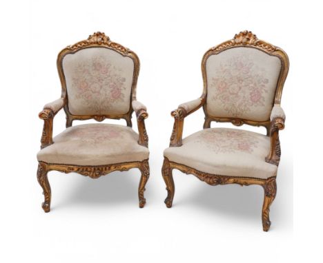 Pair of Louis XV design gilt framed armchairs, shaped cresting rail decorated with shells and foliage, upholstered in floral 