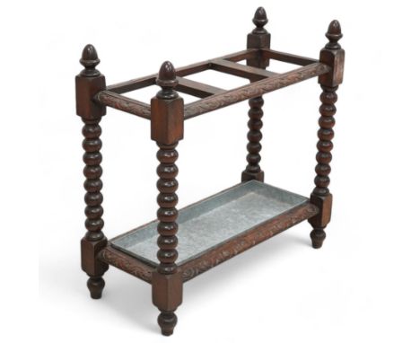 Victorian carved oak stick stand, three divisions within lunette carved frame, on bobbin turned supports united by carved str