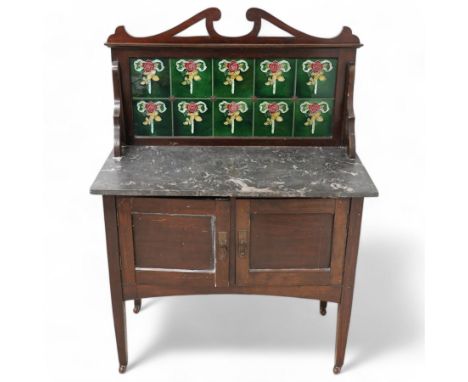 Late Victorian walnut washstand, black marble top and tiled back, enclosed by two panelled doors, on square tapering supports